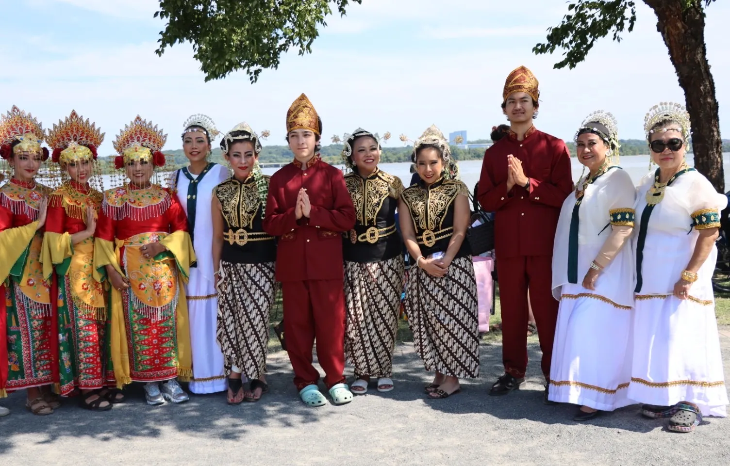 Performers in colorful traditional costumes posing together outdoors